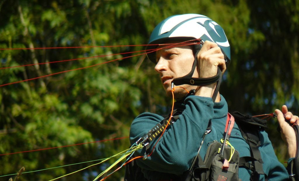 Élève en parapente sur la pente-école, suspentes tendues