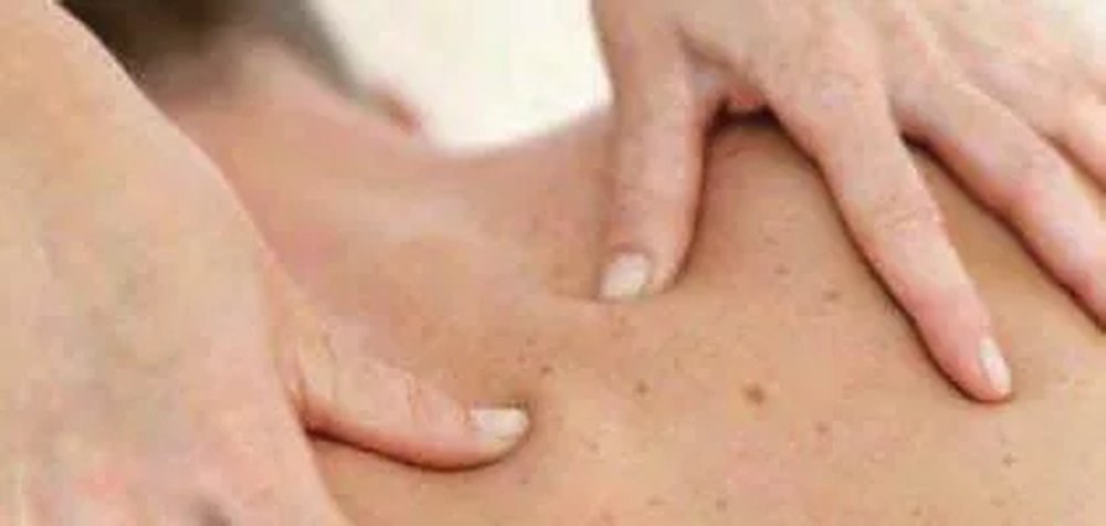 Mains d’un praticien réalisant un massage Tui Na sur le dos