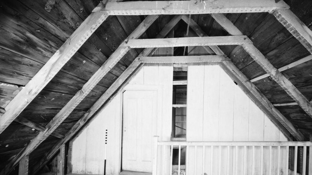 Combles sous une charpente en bois apparente, avec plancher et garde-corps